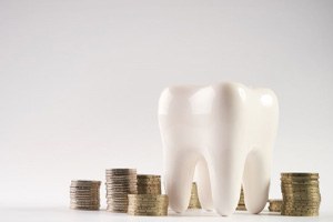 Tooth model surrounded by stacks of coins