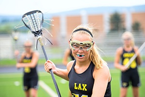 Young girl with mouthguard playing lacrosse