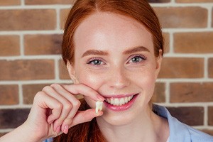 A woman holding an extracted wisdom tooth