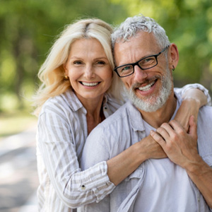 Middle-aged couple smiling after an appointment with an Ameritas dentist in Lewisville 