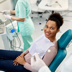 Young female smiling and talking with dentist 