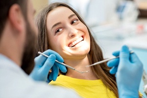 Woman smiles after getting dental crowns in Lewisville