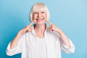 Senior woman pointing to dentures