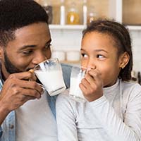 Father and daughter drinking milk together