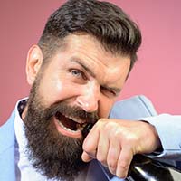 Man using teeth to open a bottle of wine