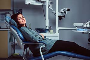 Woman smiling while visiting Lewisville emergency dentist
