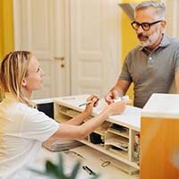 Dental employee taking payment card from a patient