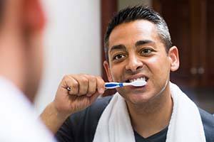 Man brushing teeth to prevent dental emergencies in Lewisville