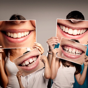 A family holding up pictures of smiles in front of their face