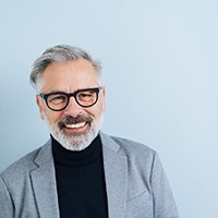 Portrait of smiling mature man against blue background