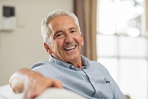 Senior man sitting on a couch and smiling