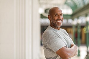 Older man with dental implants in Lewisville smiling outside