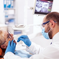 Woman receiving exam from an implant dentist in Lewisville