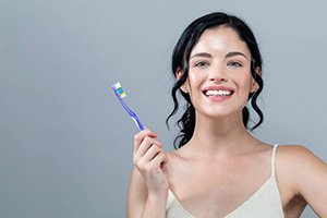 Woman holding a toothbrush and smiling