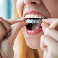 a person putting on clear aligners in Lewisville