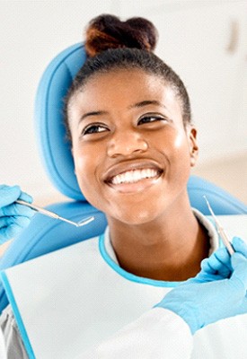 Woman in dental chair smiling at dentist