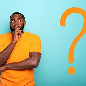 Wondering man in yellow shirt next to question mark
