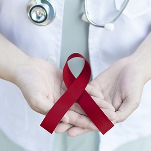 Dentist holding a maroon ribbon