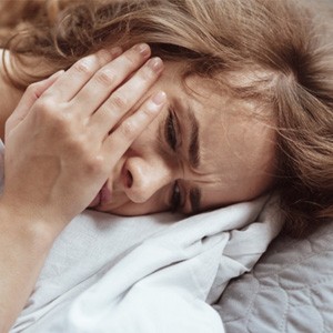 woman toothache in bed for root canal therapy in Lewisville