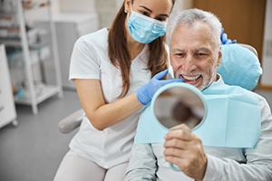 a patient checking his smile after dental implant salvage