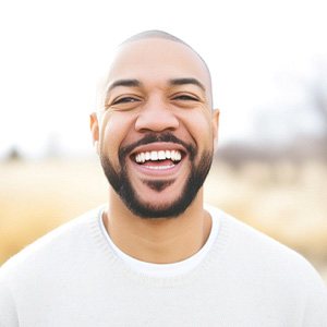 Man in white shirt smiling outside