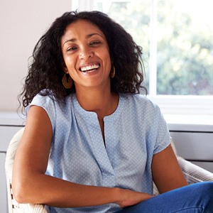 Woman smiling while sitting on chair at home