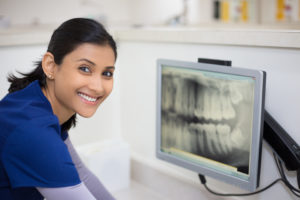 smiling dentist looking at xray