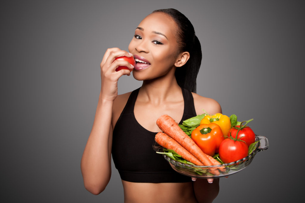 fit woman smiling eating apple