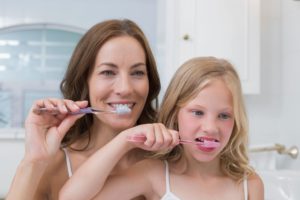 mom and daughter brushing teeth 