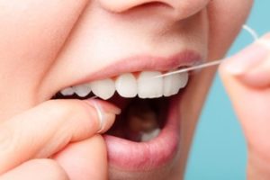 Woman flossing her teeth