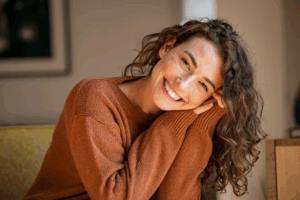 Woman smiling while sitting on her couch